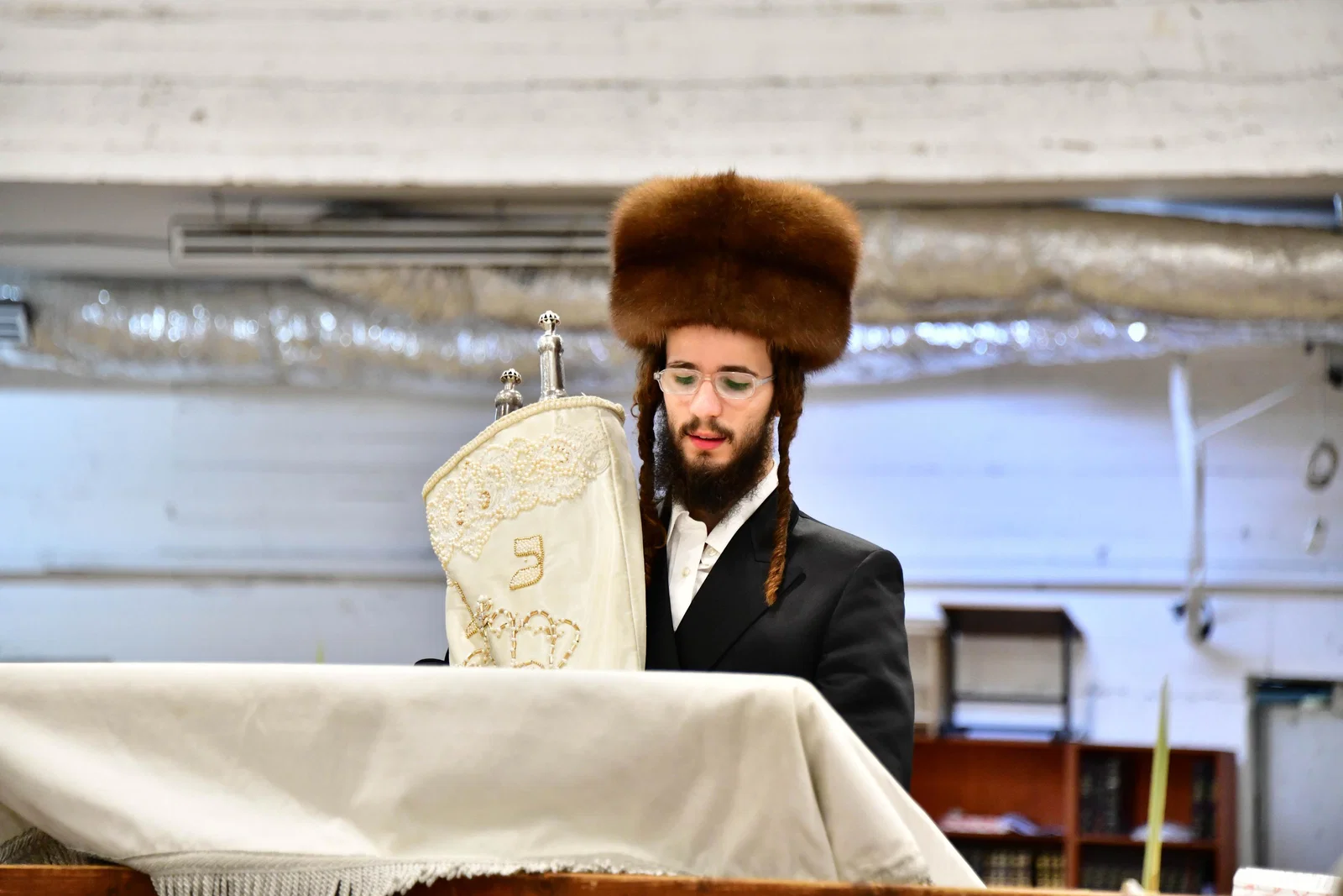 מחזה מרהיב בחסידות; הנכד עם הקאלפיק שעומד במרכז בית המדרש