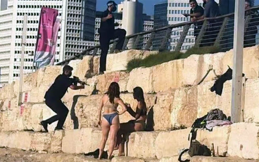 Netanyahu guard appears to raise gun near beachgoers while clearing area to film video