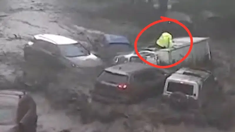 טיפס על גג המשאית: הרגע המפחיד בו שיטפון בזק השתלט על הכביש | צפו
