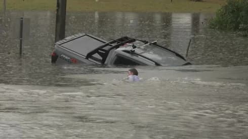 Australian reporter dives into floodwaters to save driver before car disappears